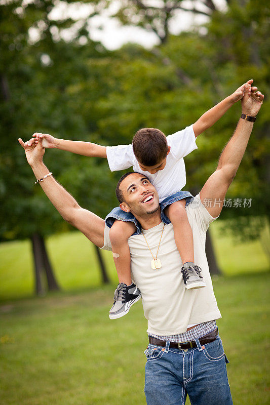 Happy Dad Carrying Son on His Shoulders Outside .快乐爸爸在外面扛儿子